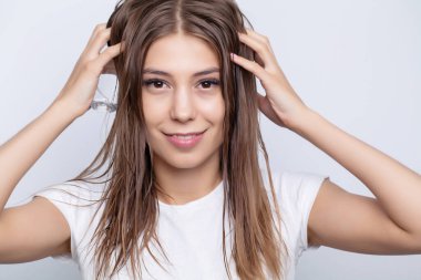Güzel saçlı bir kadın, saç uzatmak için vitamin uyguluyor.