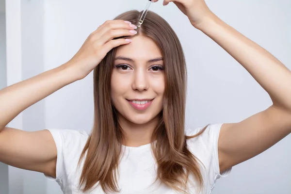 Frau mit schönem Haar, trägt Vitamine für das Haarwachstum auf — Stockfoto