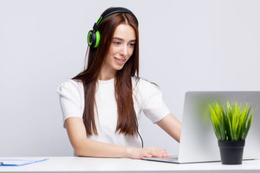 Ofisteki kulaklıklı genç kız müzik dinliyor.