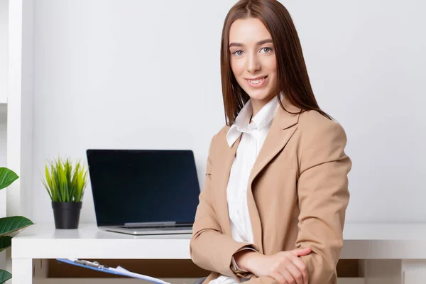 Mulher bonita em uma jaqueta trabalhando no escritório na mesa — Fotografia de Stock