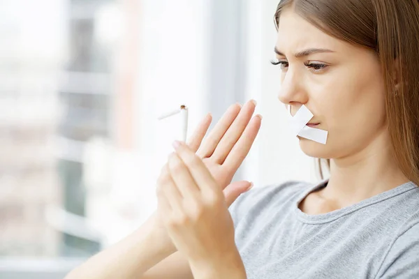 Rzuć palenie, kobieta z zamkniętymi ustami trzymająca złamanego papierosa — Zdjęcie stockowe