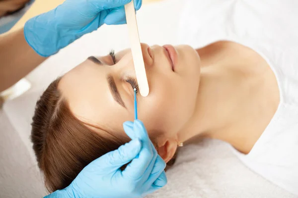 Procédure d'extension des cils, styliste professionnel allongeant les cils féminins. — Photo