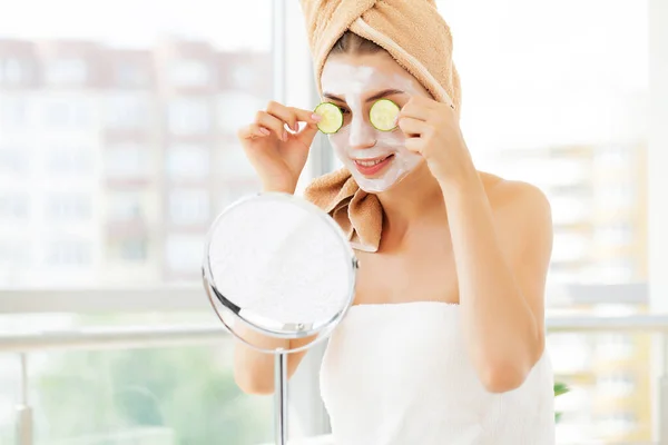 Mujer aplica mascarilla de arcilla blanca para el cuidado de la piel facial en el baño de lujo hotel — Foto de Stock