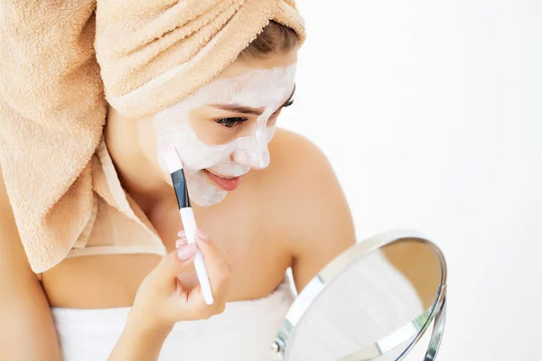 Frau trägt weiße Tonmaske zur Gesichtspflege im Hotel-Luxusbad auf — Stockfoto