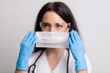 Tıbbi maskeli genç kadın doktor portresi.