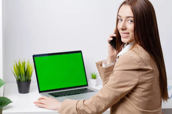 Joven mujer de negocios hermosa que trabaja en el ordenador portátil en la oficina moderna brillante — Foto de Stock