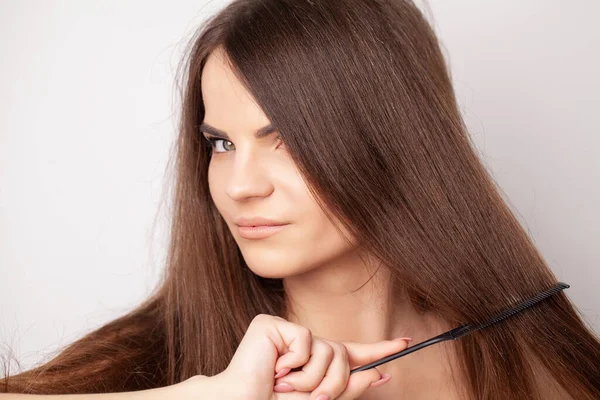 Schöne Frau kämmt ihr gesundes langes Haar — Stockfoto