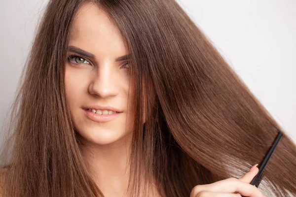 Mulher bonita pentear seu cabelo longo saudável — Fotografia de Stock