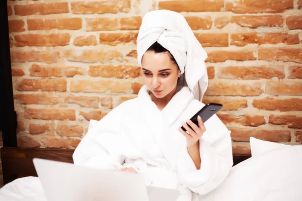 Pretty woman in white towel using her laptop in bed — Stock Photo, Image