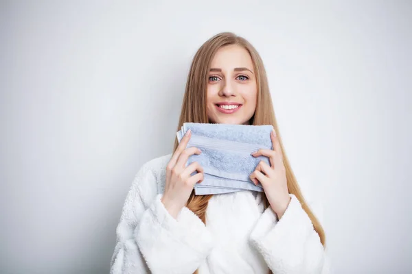 Jonge vrouw vegen haar gezicht met handdoek in badkamer. — Stockfoto