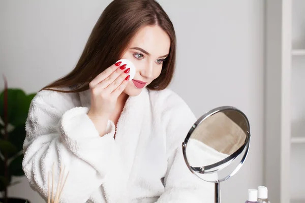 Gülümseyen genç kadın yüzünü banyoda yüz temizleme süngeriyle yıkıyor. — Stok fotoğraf