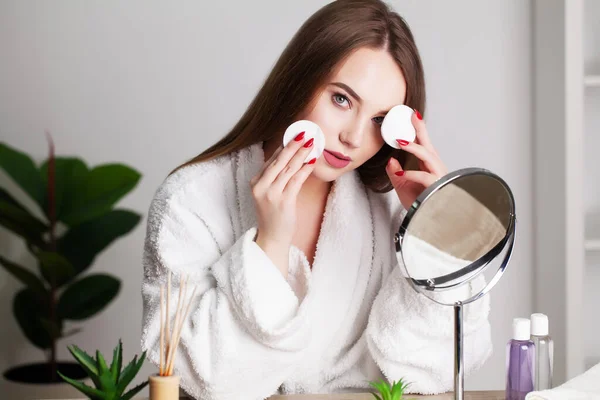 Gülümseyen genç kadın yüzünü banyoda yüz temizleme süngeriyle yıkıyor. — Stok fotoğraf