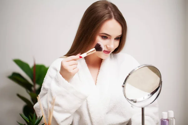 Güzel bir kadın banyoda günlük makyaj için fırça kullanıyor. — Stok fotoğraf