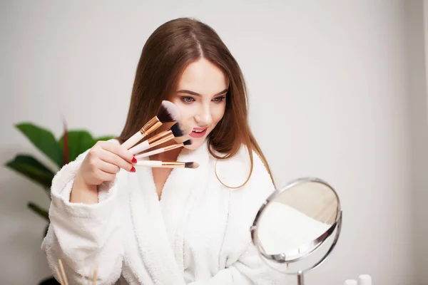 Hermosa mujer usando cepillo para el maquillaje diario en el baño — Foto de Stock