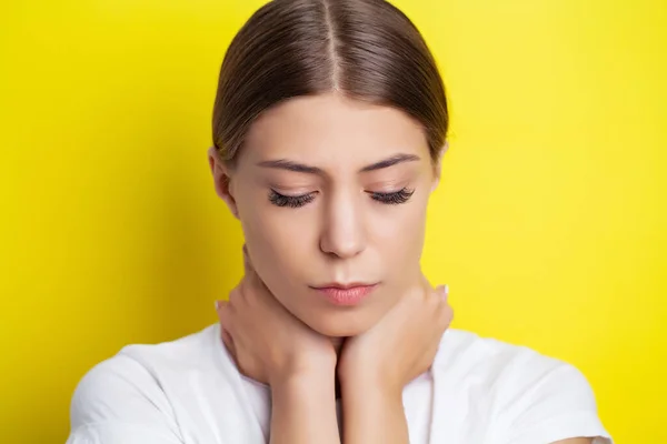 Jonge vrouw die ernstige nekpijn ervaart terwijl ze haar handen vasthoudt — Stockfoto