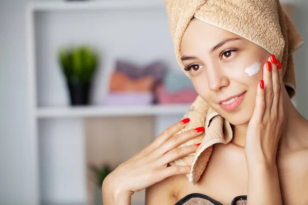 Konsep skincare, potret wanita bahagia menerapkan krim kosmetik di wajah. — Stok Foto