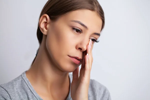 一个年轻女人的脸上感到剧痛，用手触摸痛处 — 图库照片