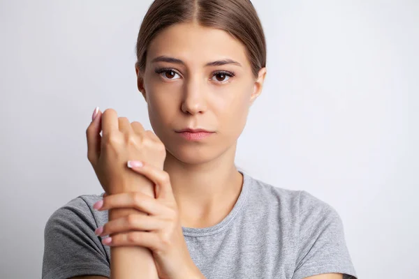 Mujer joven siente dolor severo en la mano — Foto de Stock