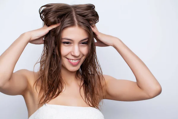 Молода жінка доглядає за волоссям, використовуючи натуральні олії та кондиціонери для догляду за волоссям — стокове фото