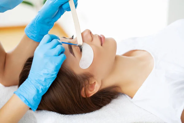 Procédure d'extension des cils, styliste professionnel allongeant les cils féminins. — Photo