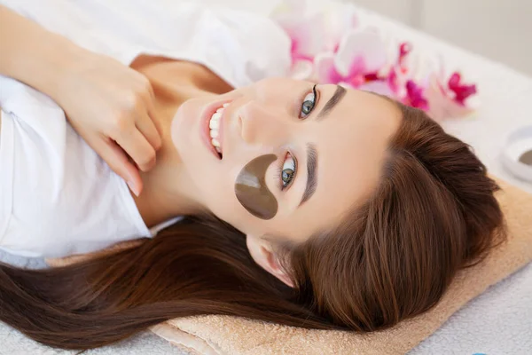 Wellness-Behandlung, schöne Frau mit Augenklappe im Schönheitssalon. — Stockfoto