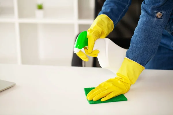 A senhora da limpeza faz a limpeza no escritório com um pano molhado — Fotografia de Stock