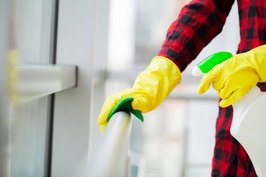 Temizlikçi kadın ıslak bir bezle ofiste temizlik yapıyor.