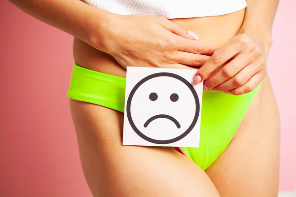 Saúde da mulher, corpo feminino segurando cartão de sorriso triste perto do estômago. — Fotografia de Stock