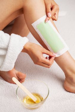 Güzellik merkezinde balmumuyla kadın bacağı cilalamak