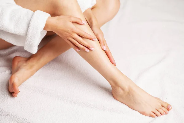 Belleza piernas delgadas femeninas después de la terapia de spa sobre fondo blanco — Foto de Stock