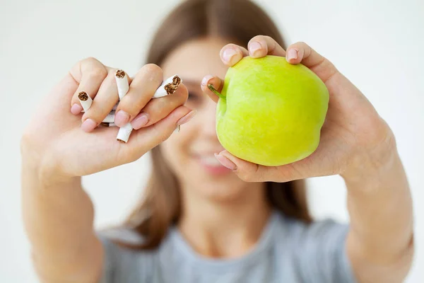 Deja de fumar, mujer sosteniendo cigarrillos rotos y manzana verde en las manos. —  Fotos de Stock