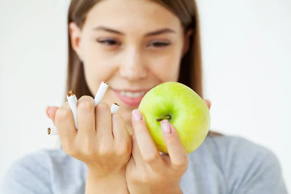 Deja de fumar, mujer sosteniendo cigarrillos rotos y manzana verde en las manos. —  Fotos de Stock