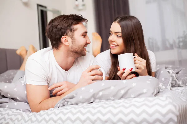 Glückliches Paar, das Spaß im Bett hat. intime sinnliche junge Paar im Schlafzimmer genießen einander — Stockfoto