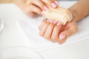 Tırnaklarında tırnak fırçası olan bir kadına yaklaş.