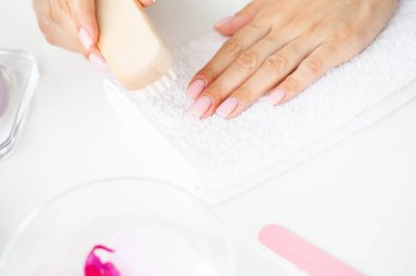 Tırnaklarında tırnak fırçası olan bir kadına yaklaş.