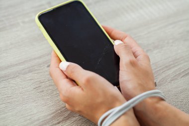 Kabloyla akıllı telefon aygıtına bağlanmış kadın ellerinin üst görüntüsünü kapat