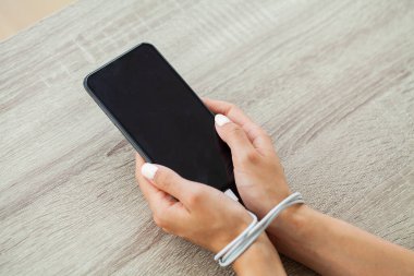 Kabloyla akıllı telefon aygıtına bağlanmış kadın ellerinin üst görüntüsünü kapat