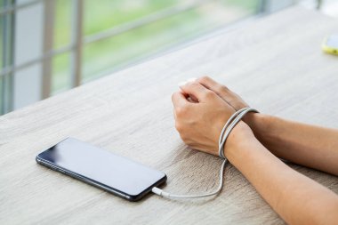 Kabloyla akıllı telefon aygıtına bağlanmış kadın ellerinin üst görüntüsünü kapat