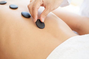 Sıcak taşlarla masaj yaptıran bir kadın.