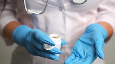 Doktor elinde çeşitli haplar tutuyor.