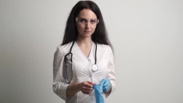 Läkaren i vit rock tar på sig handskar — Stockvideo