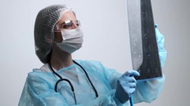 Doktor hastanın beyninin MR görüntüsünü inceliyor.