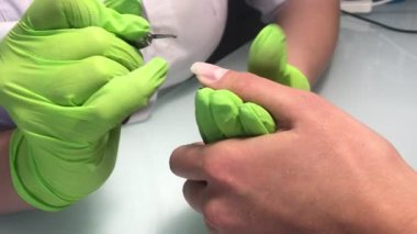 Güzellik stüdyosunda yeni manikür yapan bir kadın.