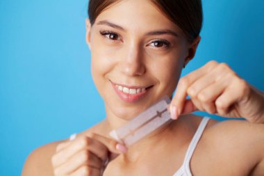 Güzel, gülümseyen kız diş beyazlatan striptiz yapıyor.