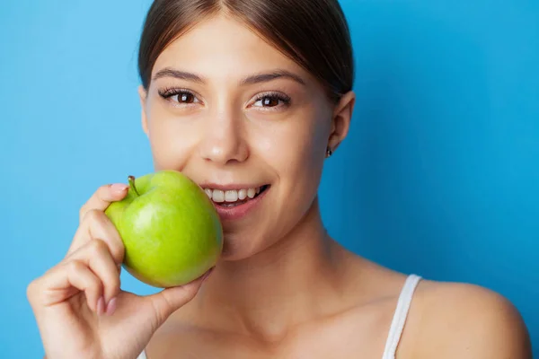 Πορτρέτο μιας χαρούμενης νεαρής γυναίκας με τέλειο χαμόγελο τρώγοντας πράσινο μήλο — Φωτογραφία Αρχείου