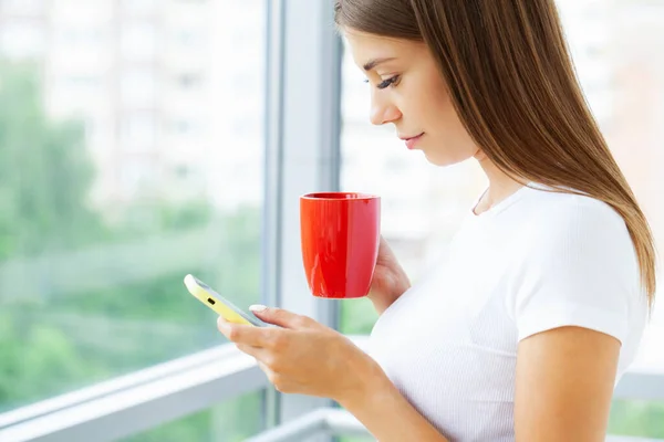 Kvinna håller smartphone, skriva meddelande, chatta med vänner i sociala nätverk — Stockfoto