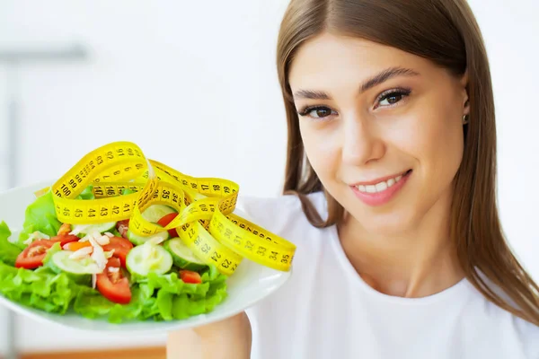 Junge Frau hält gesunden Salat mit grünen Zutaten und gelbem Klebeband in der Hand — Stockfoto