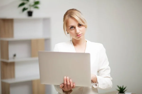 Ung kvinna som arbetar på laptop på kontoret. — Stockfoto