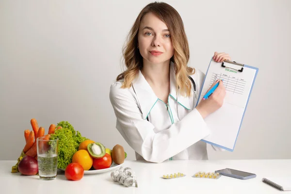 Médico nutricionista joven escribiendo plan de dieta, alimentación saludable — Foto de Stock