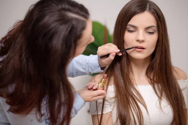 Make up artist doing professional make up of young woman — Stock Photo, Image